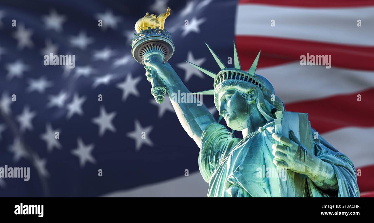 the statue of liberty with the blurry american flag waving in the background. Democracy and freedom concept Stock Photo