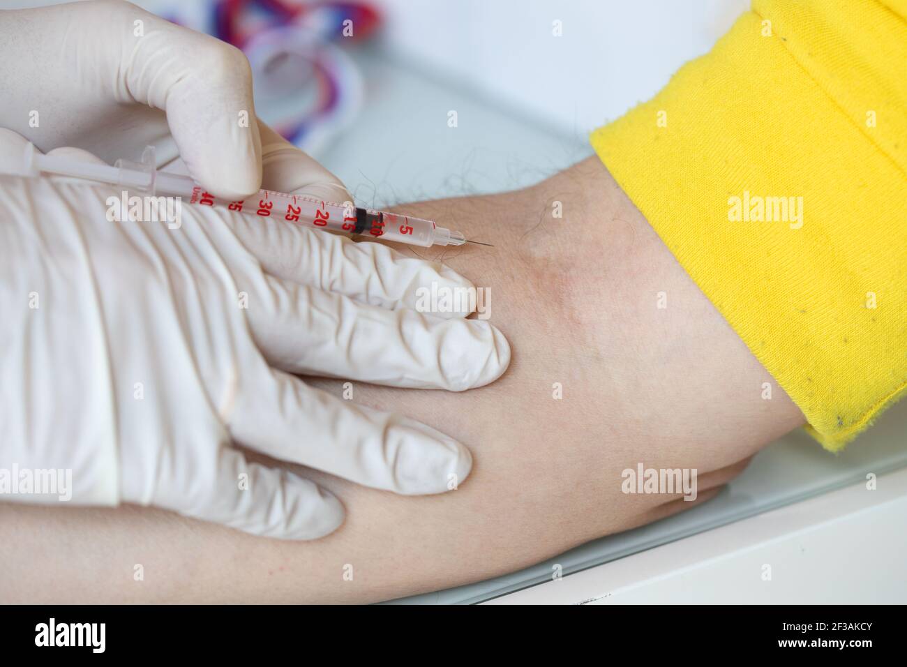 Medical assistant is about to administrate medication in the arm of a man. Closeup Stock Photo