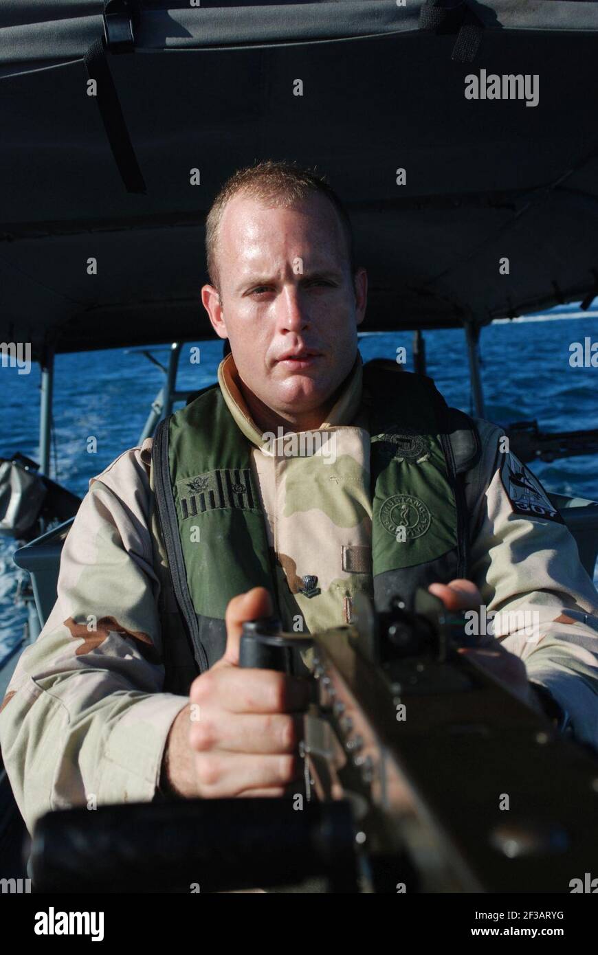 Petty Officer 3rd Class John Ebert, coast guard, from Port Security Unit 307 out of Clearwater, Fla., mans a .50 caliber machine gun during a patrol in Guantanamo Bay, June 10. PSU 307 provides maritime anti-terrorism and force protection for the waters in and around U.S. Naval Station Guantanamo Bay and Joint Task Force Guantanamo. JTF Guantanamo conducts safe and humane care and custody of detained enemy combatants. The JTF conducts interrogation operations to collect strategic intelligence in support of the Global War on Terror and supports law enforcement and war crimes investigations. JTF Stock Photo