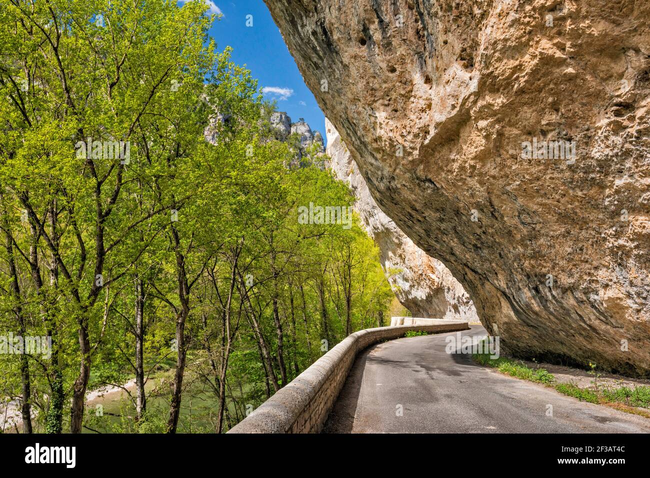 Rock overhang at road at Cirque des Baumes, Gorges du Tarn, river Tarn on left, Lozere department, Occitanie region, France Stock Photo