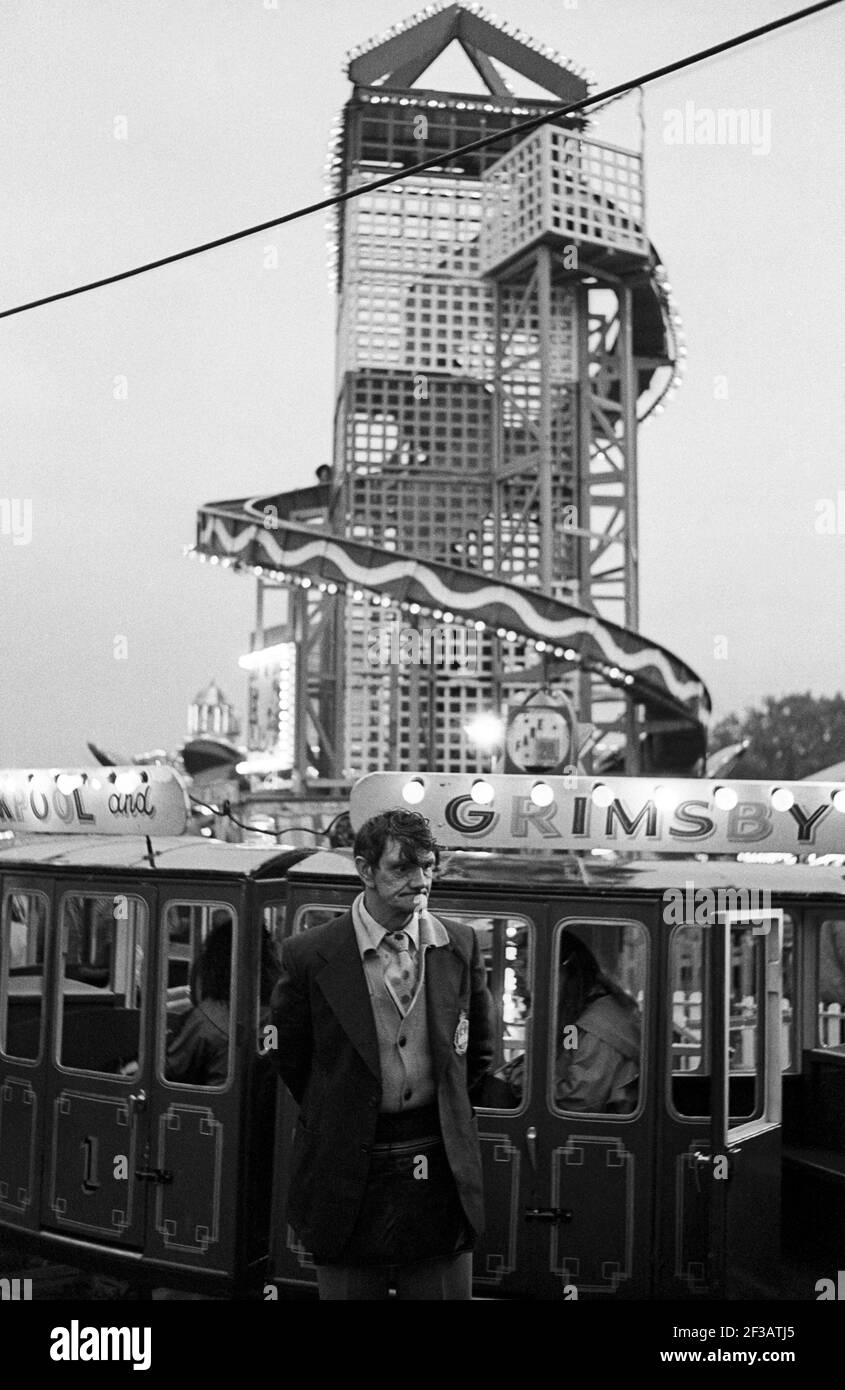 Fairground ride operator in front of rides at the annual Nottingham Goose Fair England UK photographed in October 1981. Stock Photo