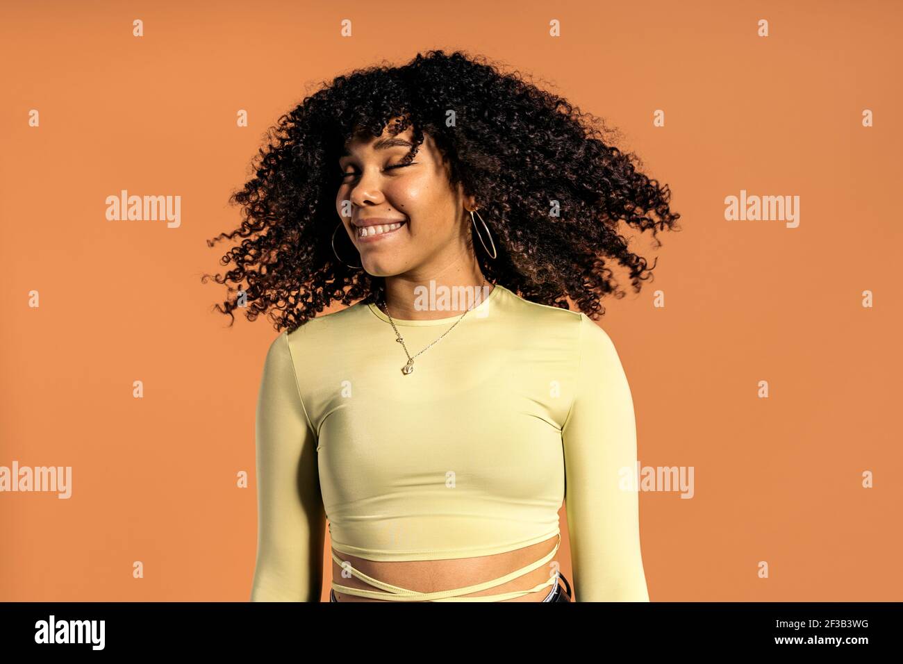 Stock photo of beautiful african woman moving her curly hair in studio shot  Stock Photo - Alamy