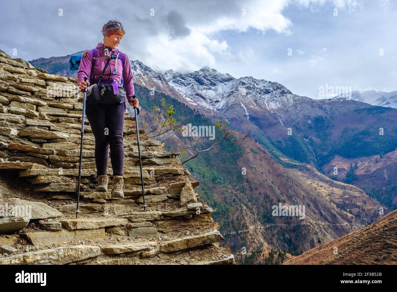 Trekking on the Dolpo circuit trek in the typically Tibetan western Nepal region of Dolpo. Female trekker on ancient pathway Stock Photo