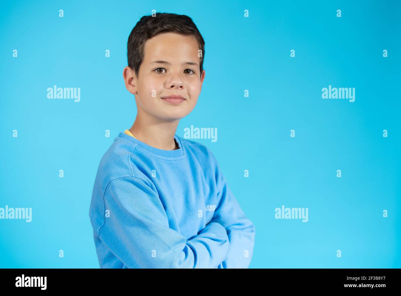 Portrait of a handsome smiling young boy over blue background Stock ...
