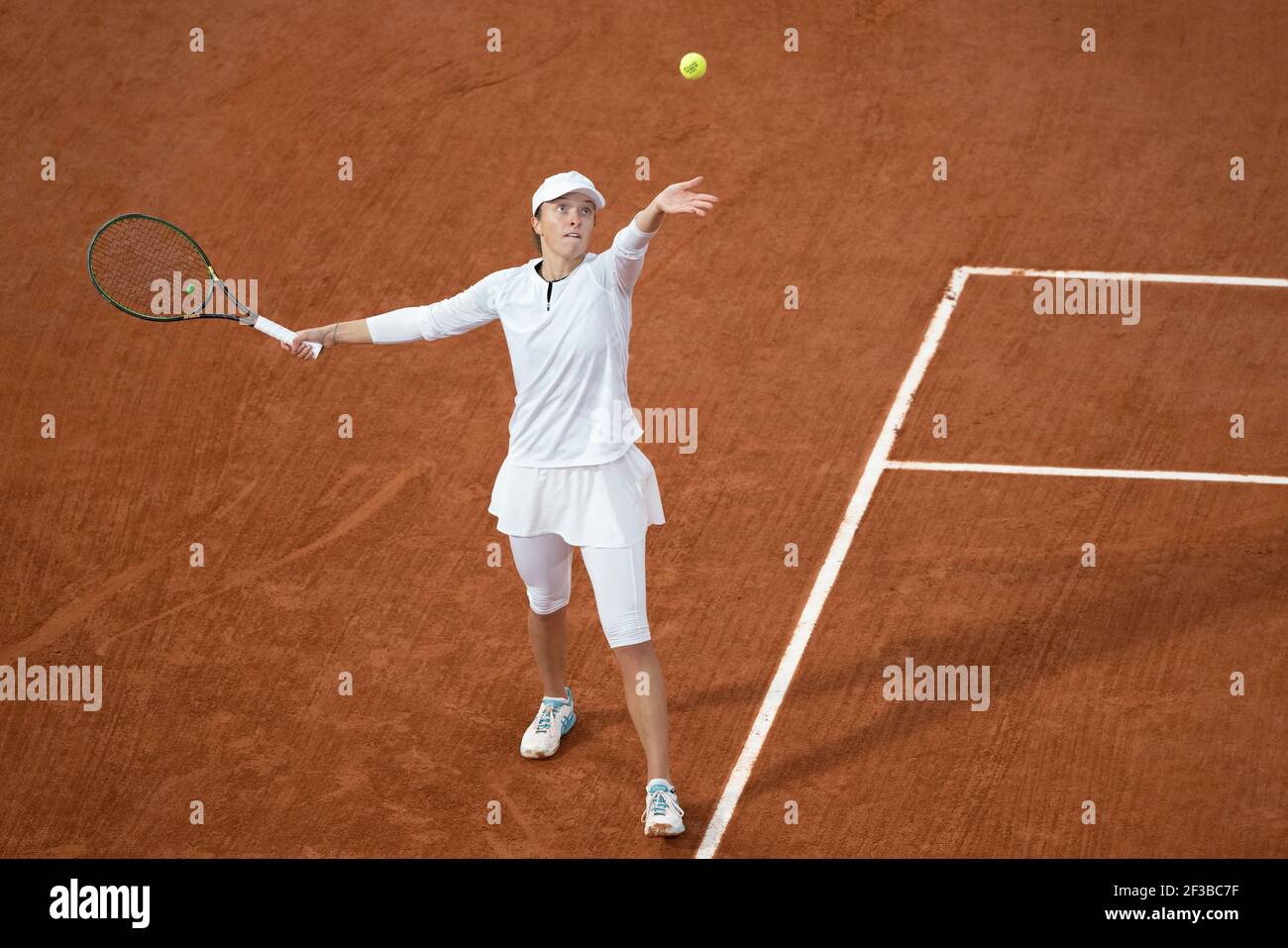 Polish tennis player Iga Swiatek tossing ball in the air during French