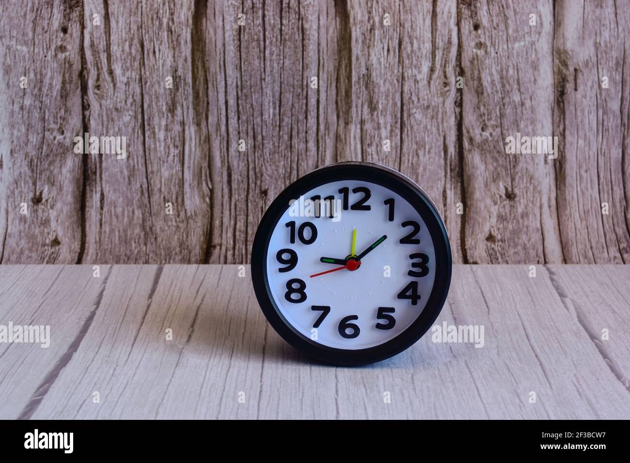 Black alarm clock on wooden table, space for text Stock Photo