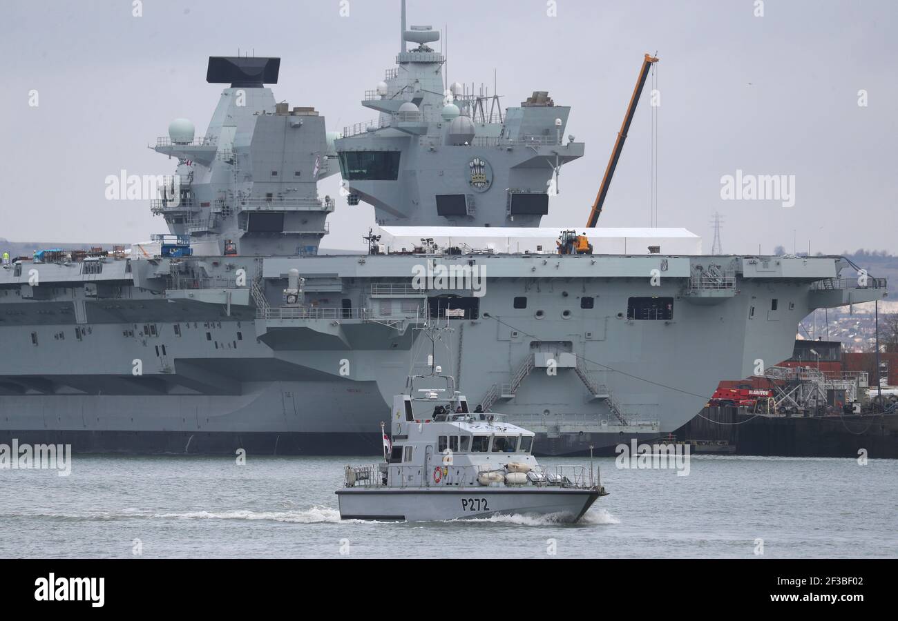 The Royal Navy archer class patrol vessel HMS Smiter passes the aircraft carrier HMS Prince of Wales at HMNB Portsmouth, ahead of the publication of the Government's review of security, defence, development and foreign policy. Picture date: Tuesday March 16, 2021. Stock Photo