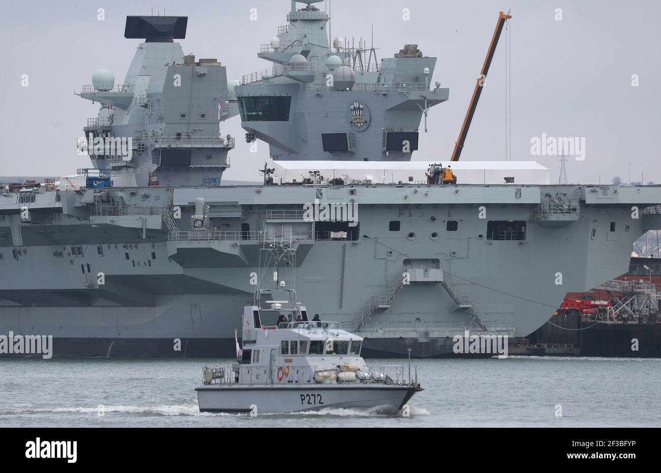 The Royal Navy archer class patrol vessel HMS Smiter passes the aircraft carrier HMS Prince of Wales at HMNB Portsmouth. Picture date: Tuesday March 16, 2021. Stock Photo