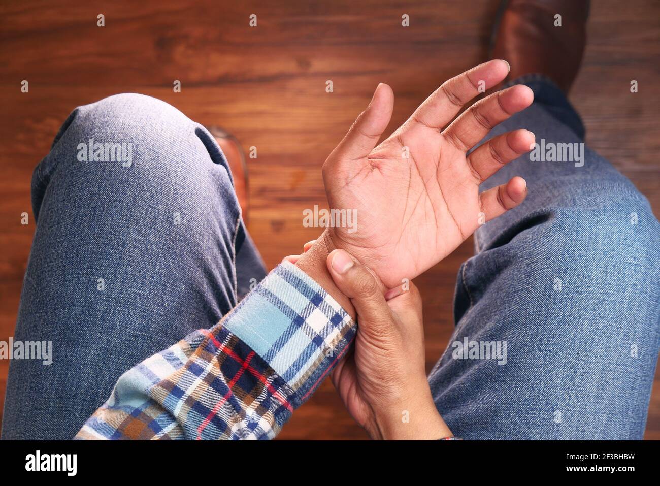top view of man suffering pain in hand close sitting on chair  Stock Photo