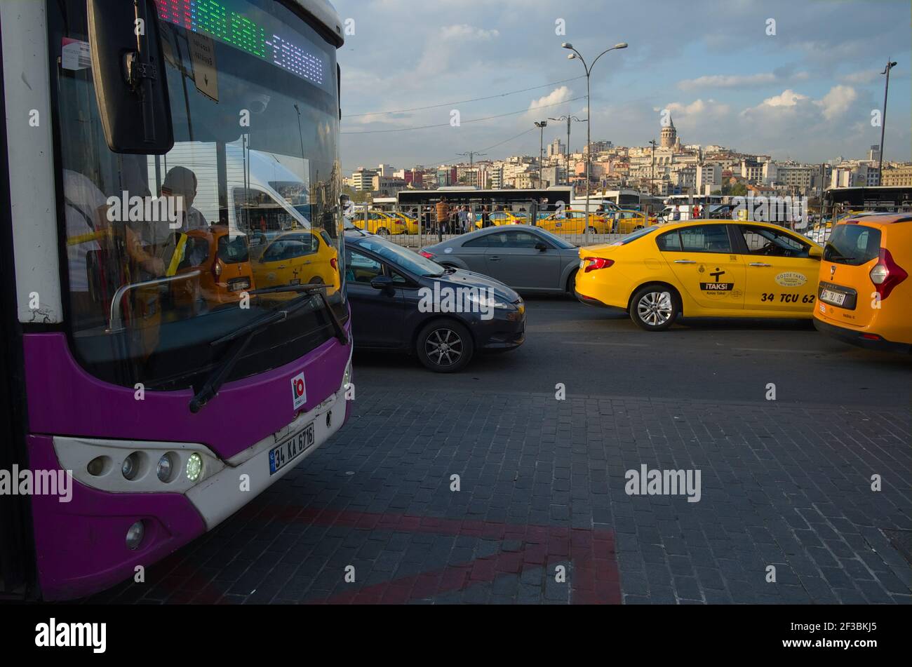 Istanbul, Turkey - September, 2018: Public bus stop and yellow taxi cabs against Galata Tower view. Traffic on roads in Istanbul Stock Photo