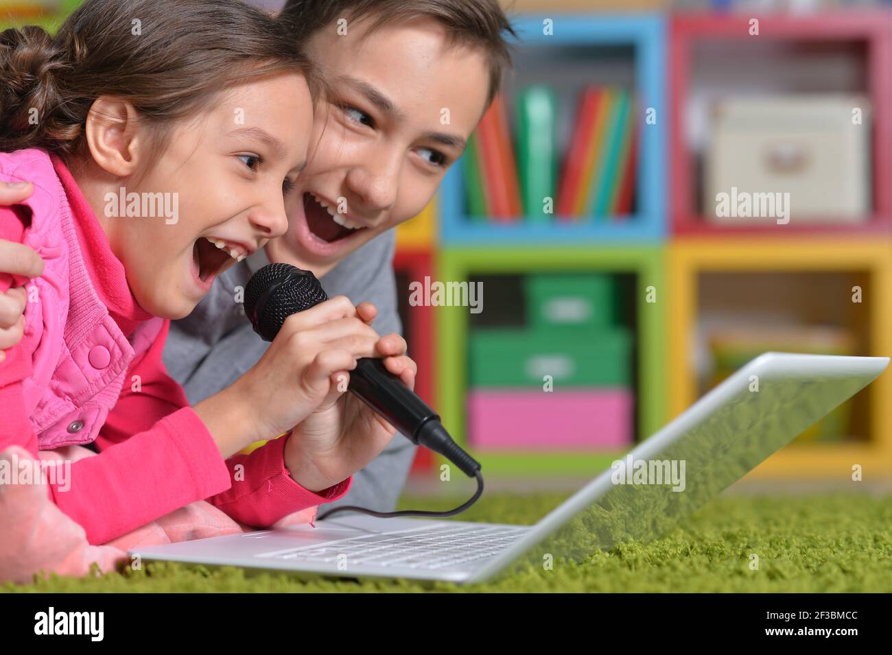 Adorable little girl and boy singing karaoke Stock Photo Alamy