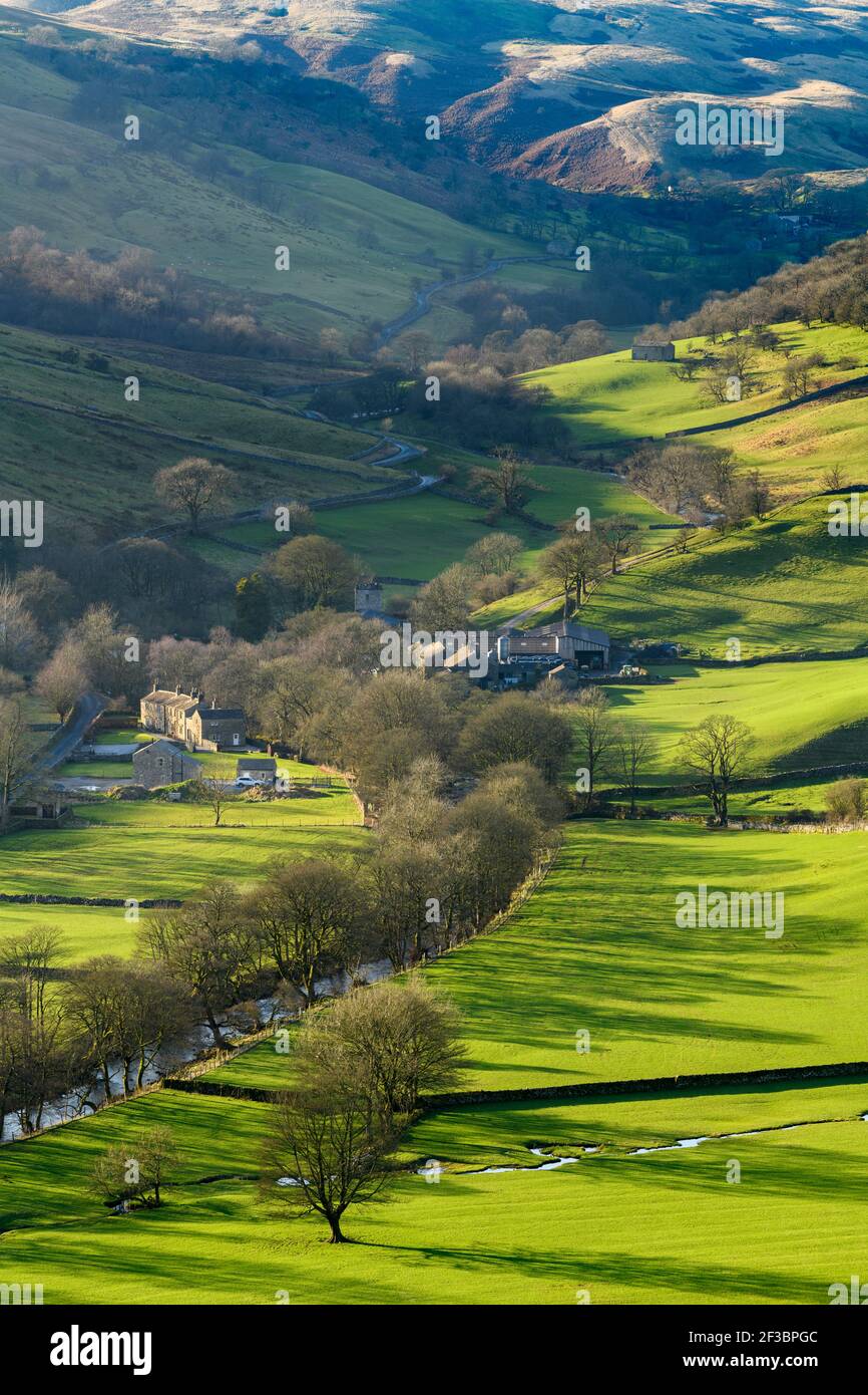 Picturesque Dales village (cottages & farms) & River Wharfe, nestling by hills & hillsides in steep-sided valley - Hubberholme, Yorkshire, England, UK Stock Photo