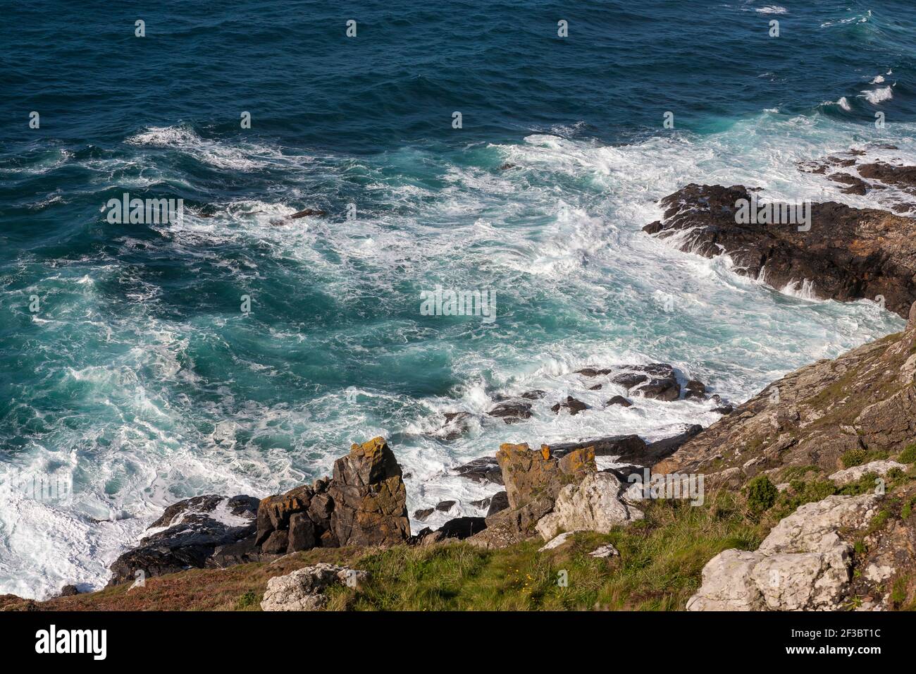 Surf on rocks on Cape Cornwall, West Penwith, Cornwall, UK Stock Photo