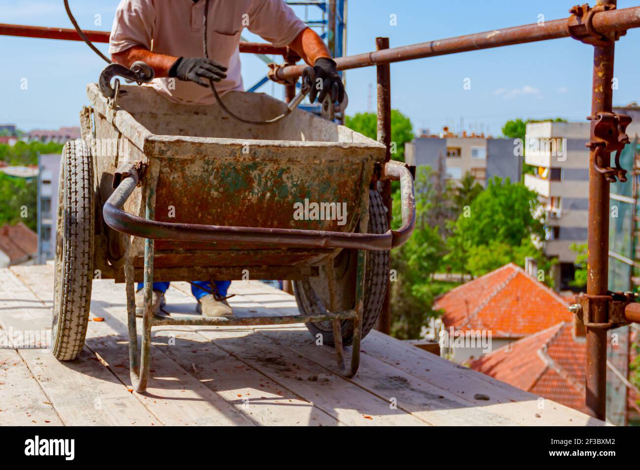 Construction worker is attaching crane hooks to industrial tipping
