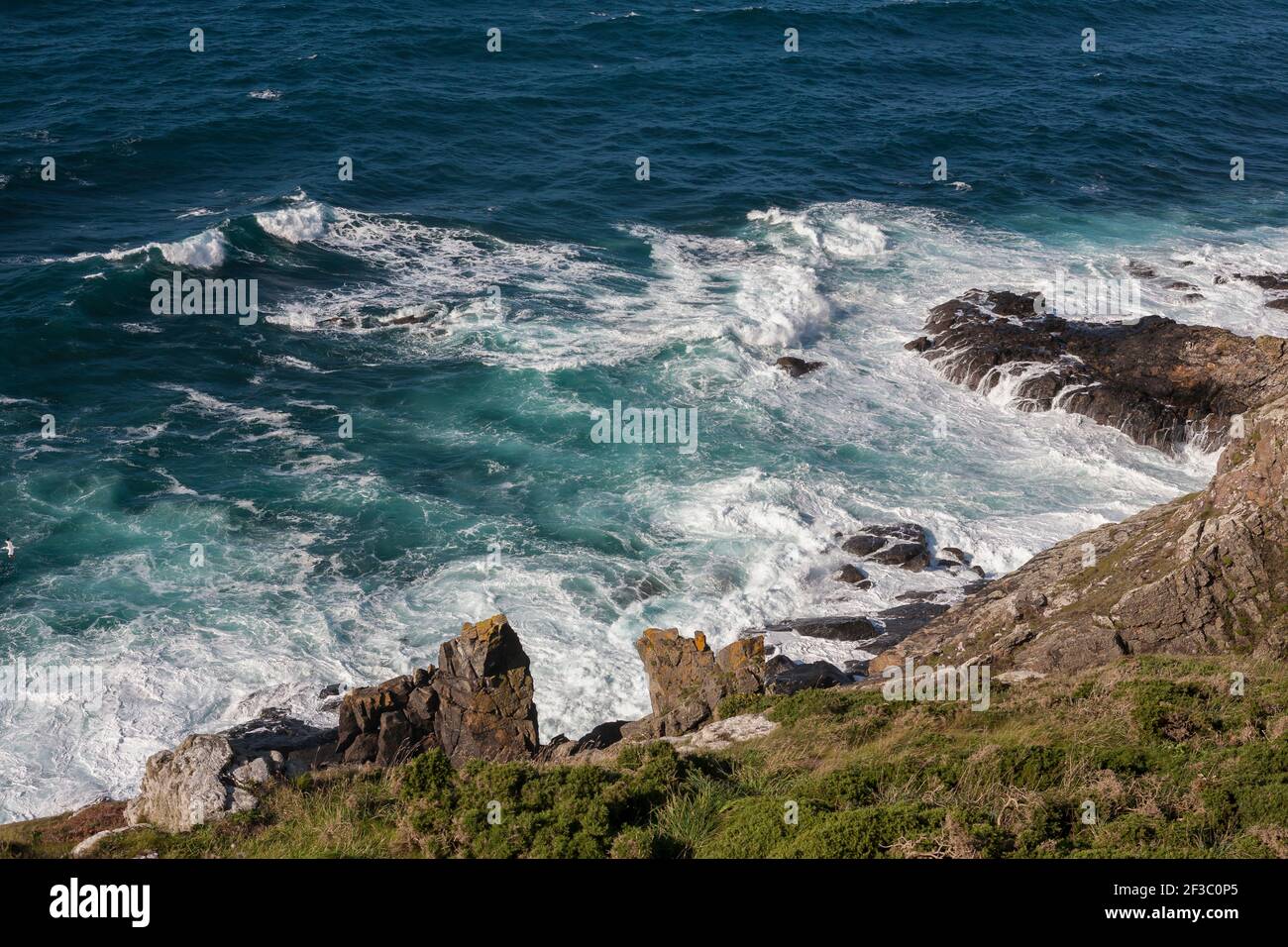 Surf on rocks on Cape Cornwall, West Penwith, Cornwall, UK Stock Photo