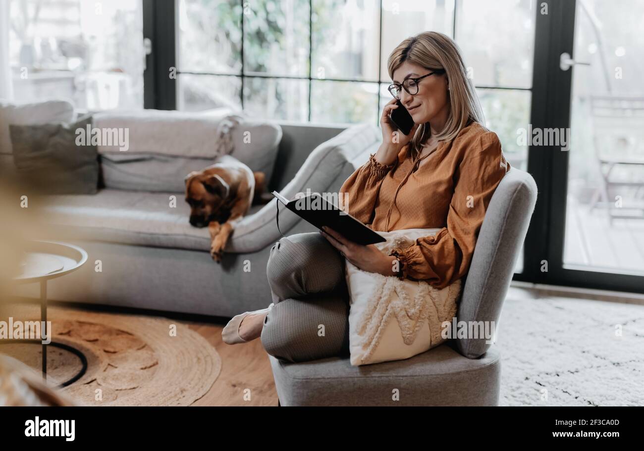 Businesswoman working at home and managing her business via home office during Coronavirus or Covid-19 quarantine Stock Photo