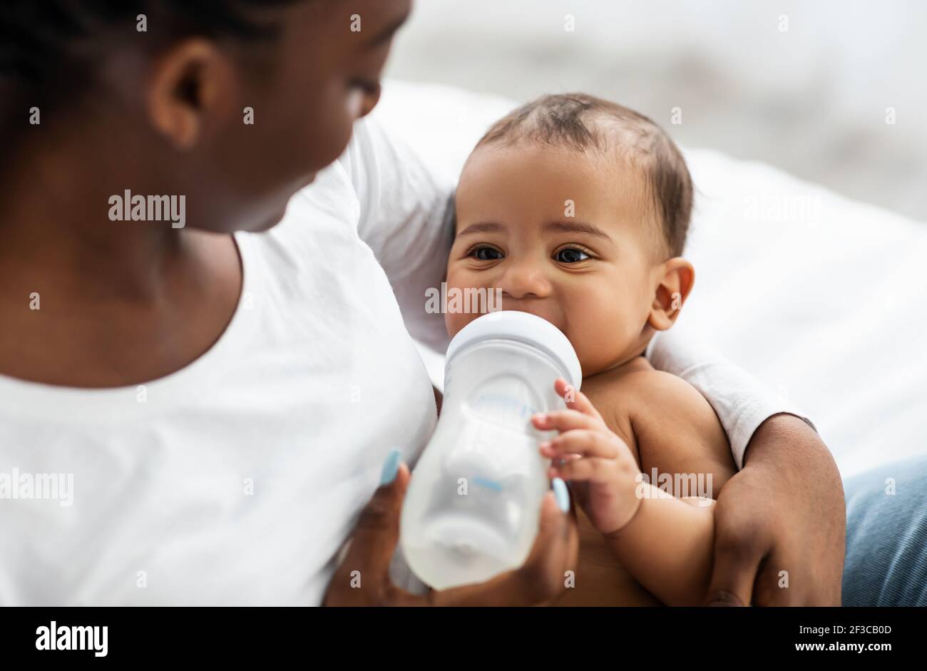 African American man feeding baby son bottle Stock Photo - Alamy