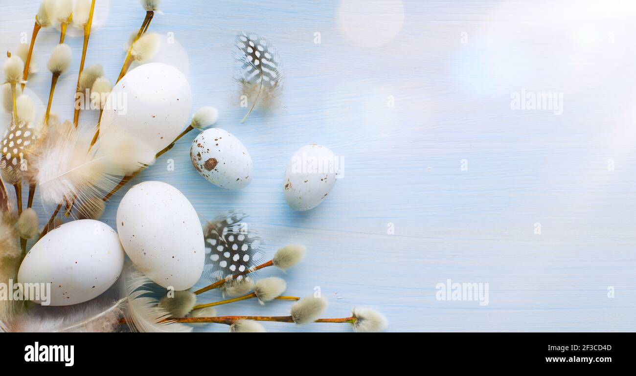 Flat lay Easter composition with a willow branch and eggs on a blue background Stock Photo