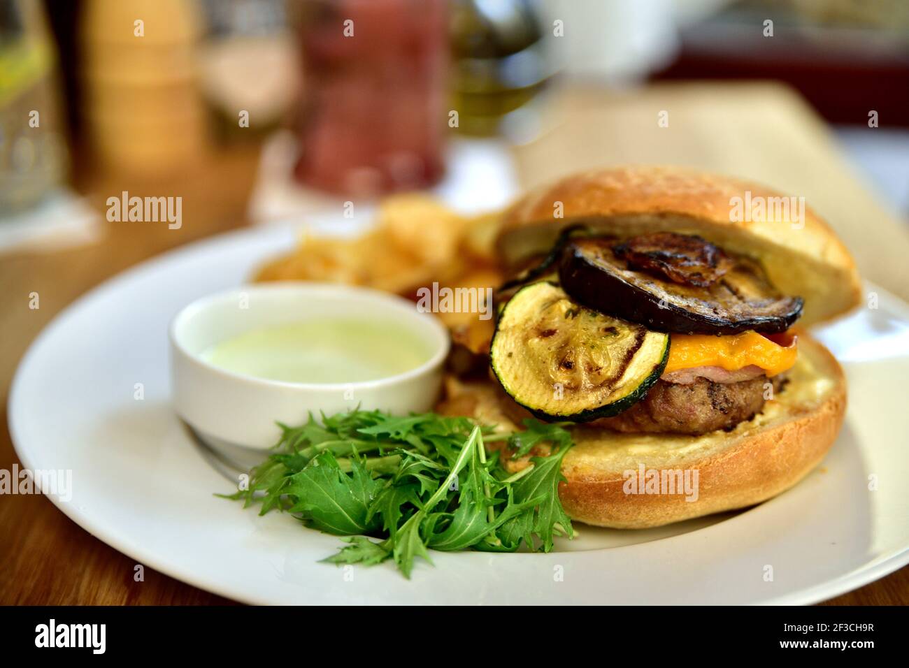 Restaurant food with fresh ingredients - hamburger with cheddar cheese, zucchini, potato slices and tartar sauce Stock Photo