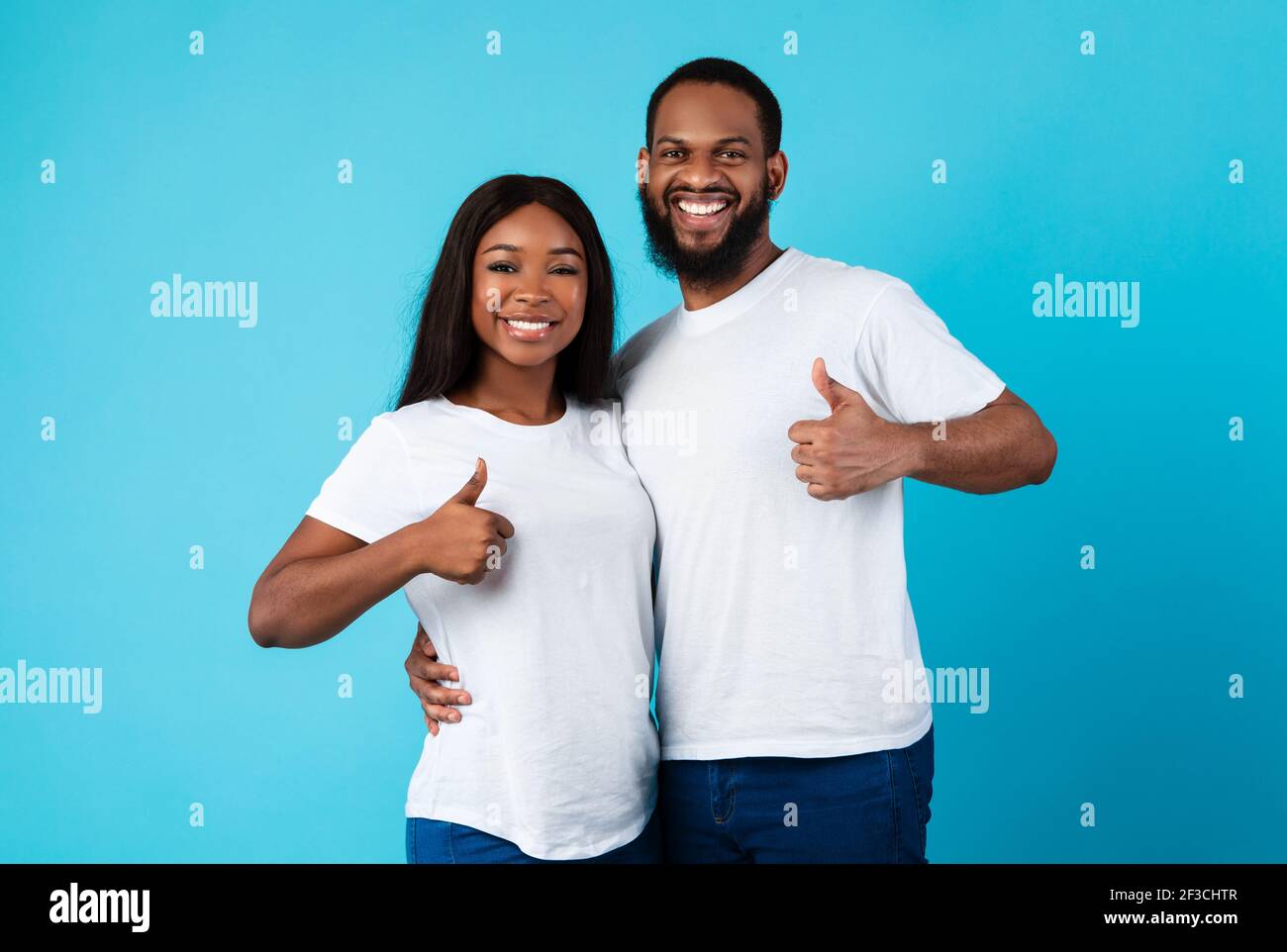 Happyafro couple gesturing thumbs up and smiling Stock Photo