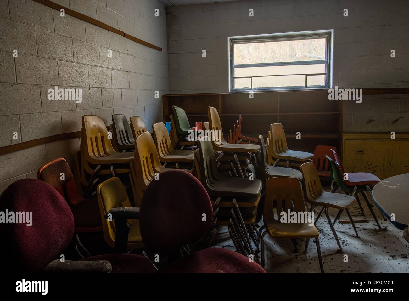 Old chairs are stacked in the corner of an abandoned classroom in Appalachian Kentucky. Stock Photo
