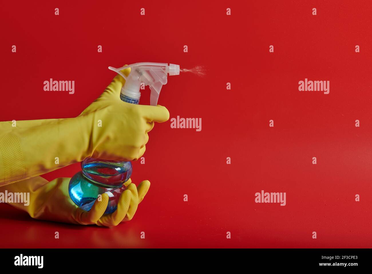 yellow gloves on a red background with a spray bottle Stock Photo - Alamy