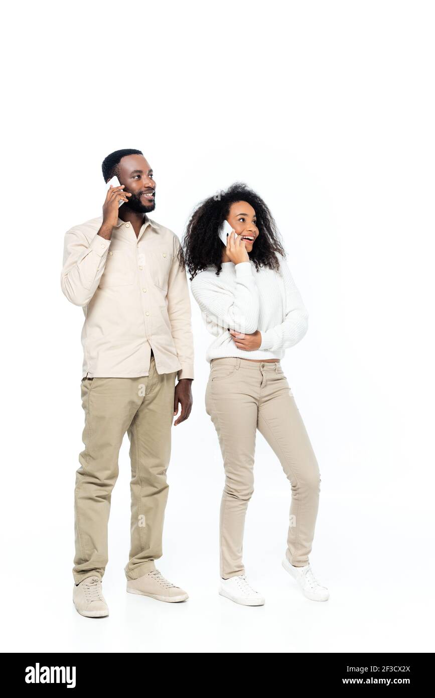 happy african american couple talking on mobile phones and looking away ...