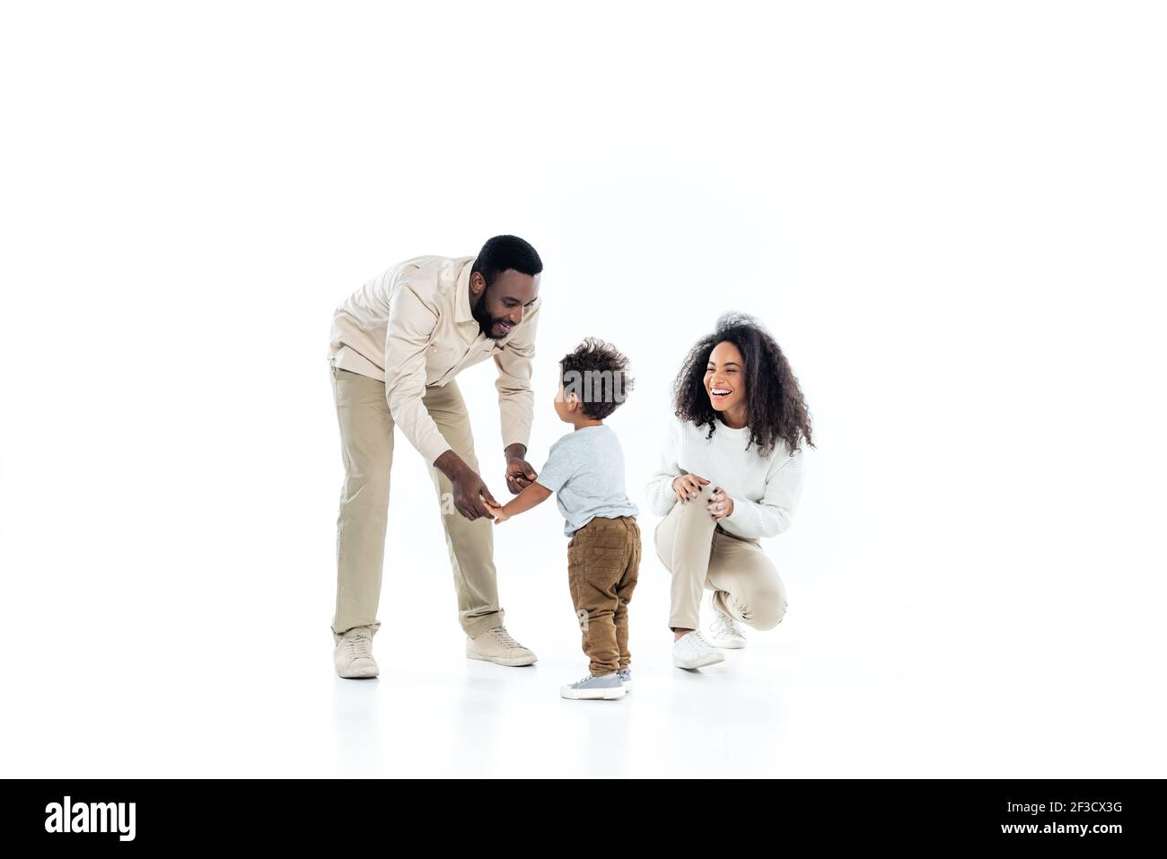 happy african american father holding hands of little son near laughing ...