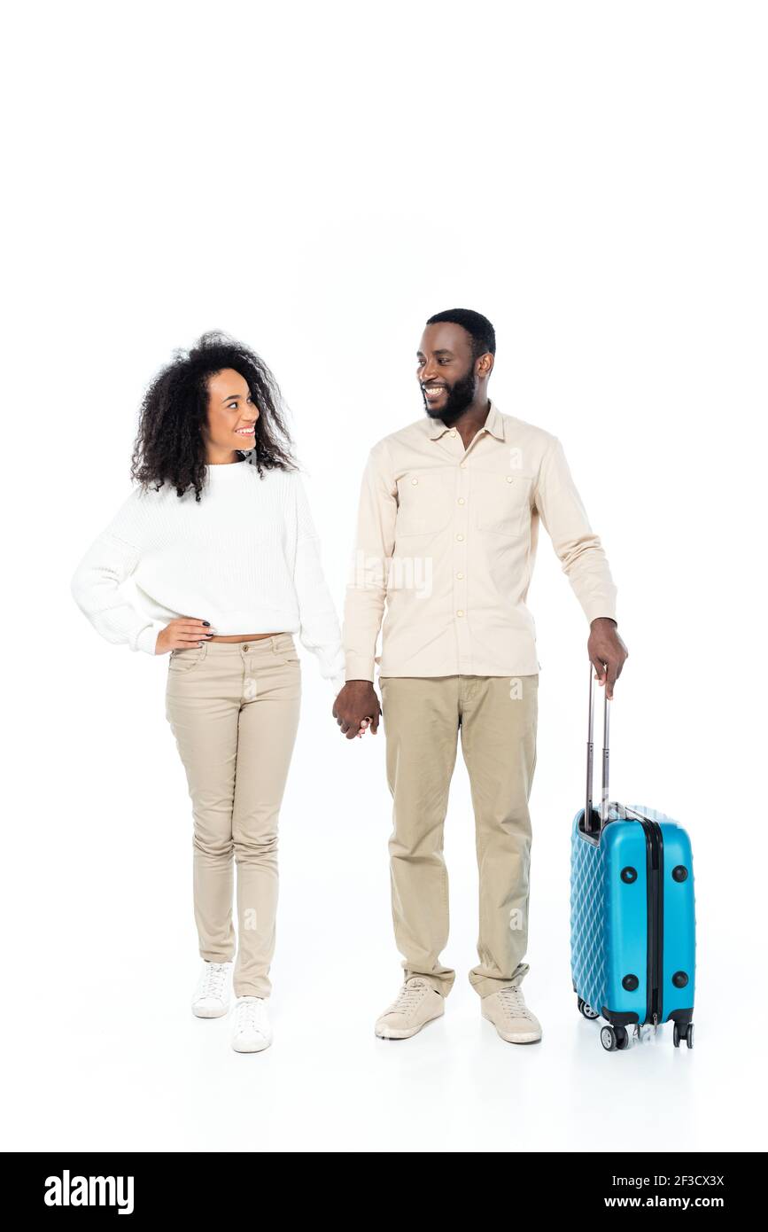 happy african american couple of travelers holding hands while smiling ...