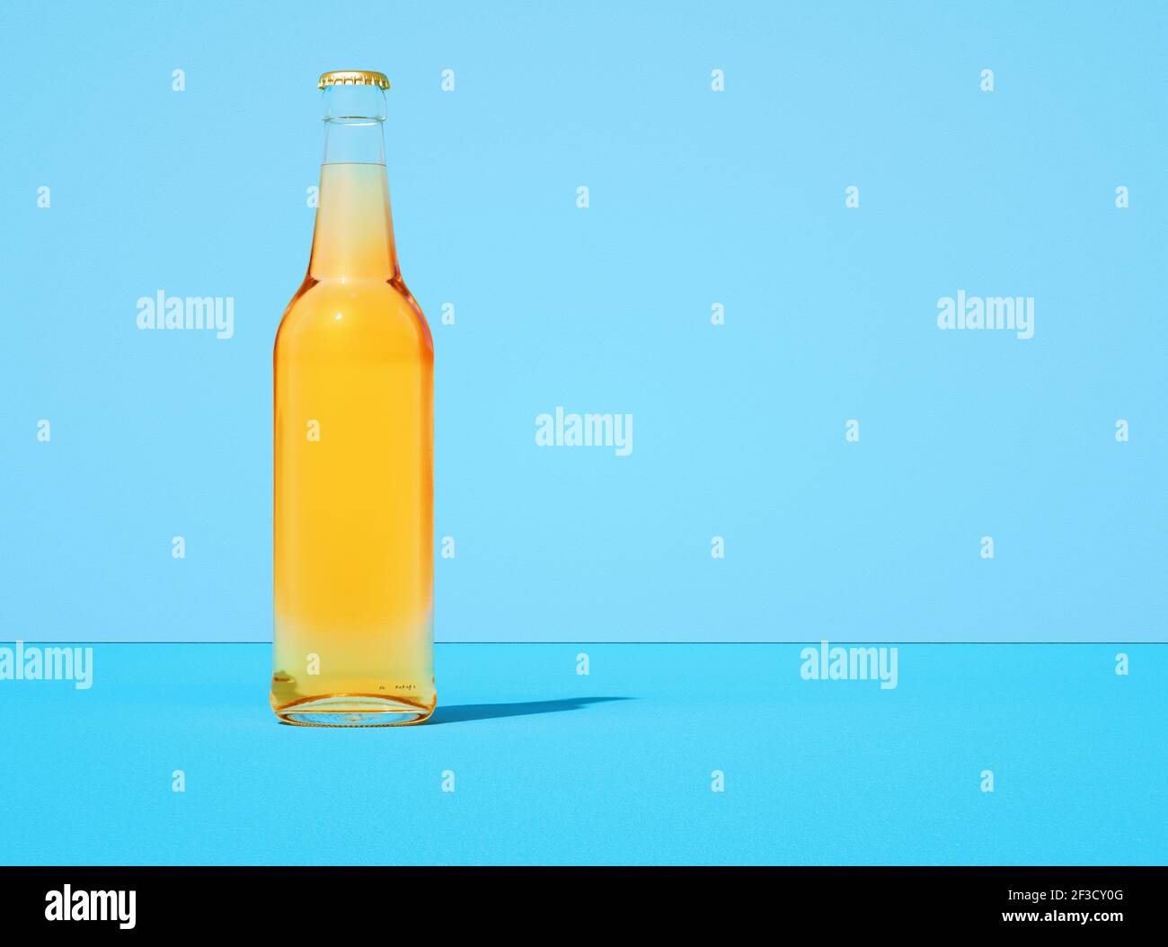 Transparent glass beer bottle on retro pastel light blue color