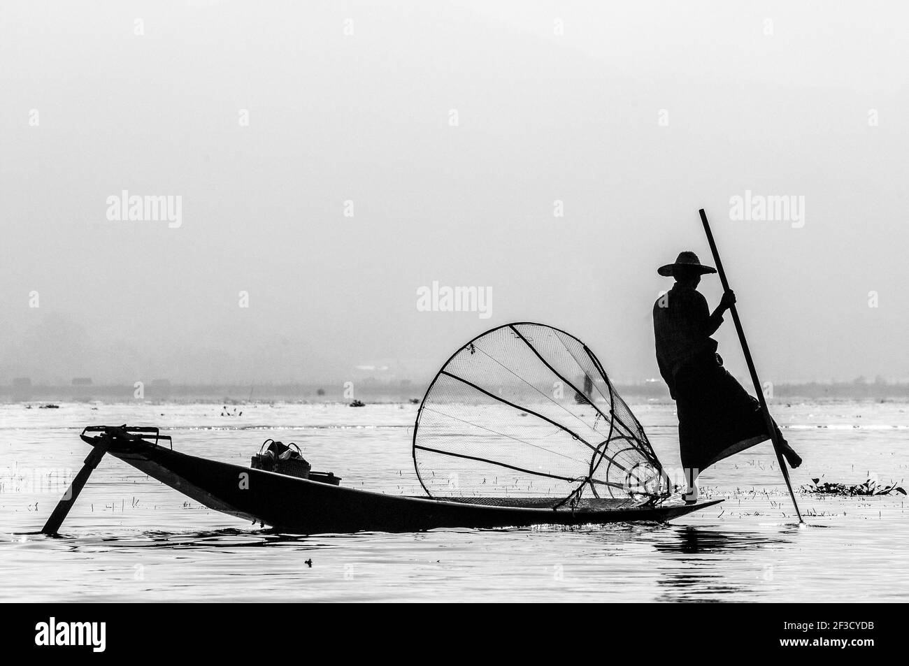 Traditional Burmese fisherman at Inle lake, one legged rowing style, the art of balance in perfection, Myanmar. Stock Photo