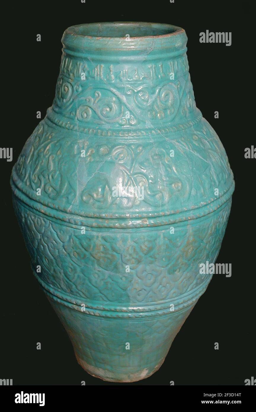 Large Turquoise Jar, Iran, 12th-13th century. Motifs typical of the Seljuq period including winged griffins and arabesque design. with inscriptions of good wishes  in small kufic script. Stock Photo