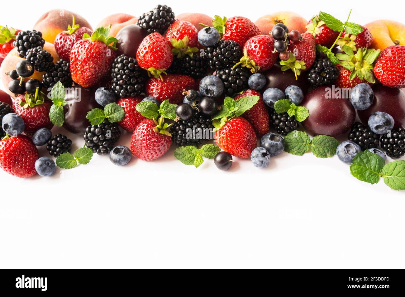 Mix berries and fruits on white background. Ripe blackberries, strawberries, bleberries, blackcurrants and plums. Top view. Background berries and fru Stock Photo