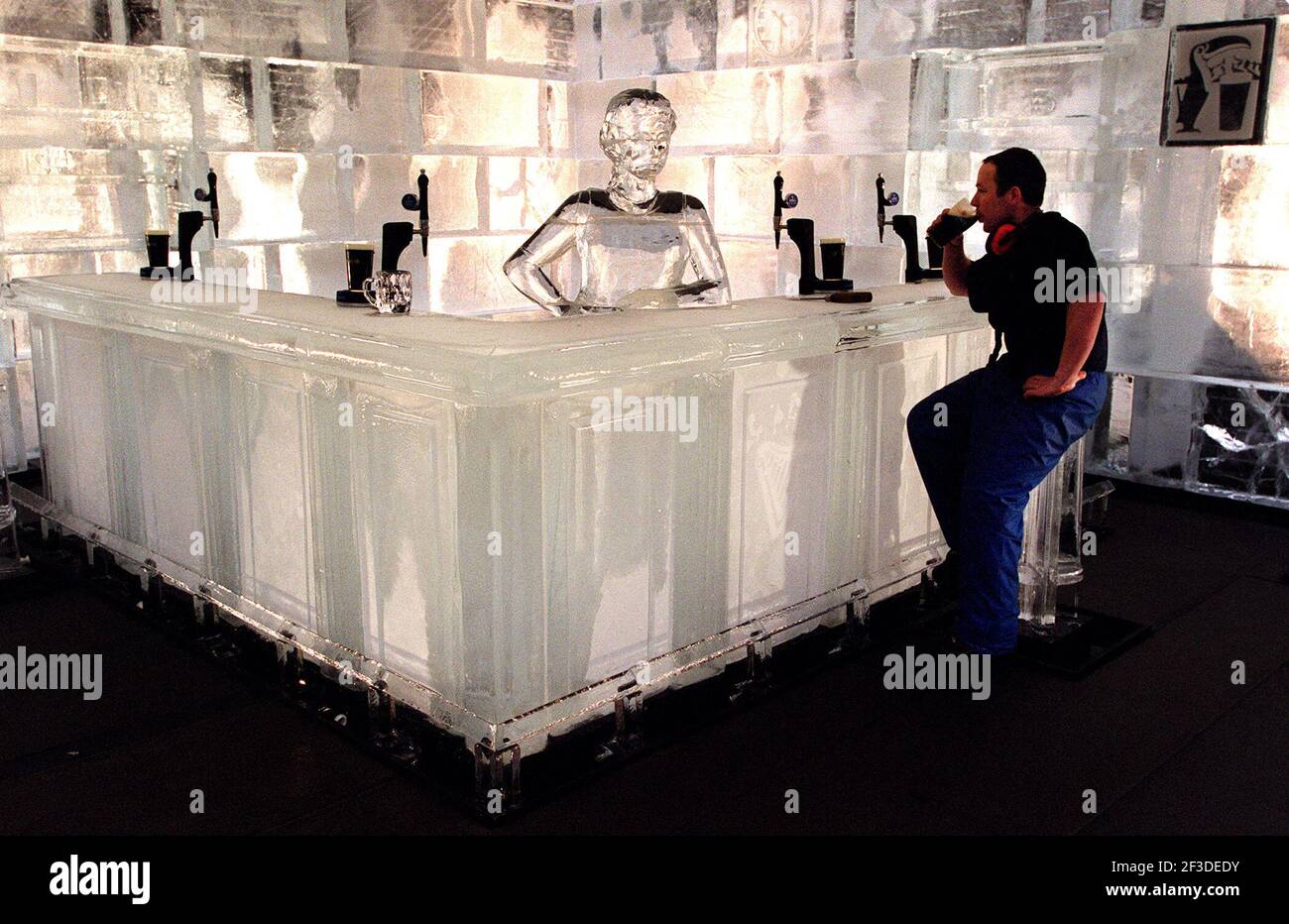 A WORKMAN SAMPLES A COLD GUINNESS AT THE ICE SCULPTURE BAR ON DISPLAY FOR A LIMITED TIME(UNTIL IT MELTS!) AT THE BROADGATE CIRCUS TODAY. SPONSORED BY GUINNESS . Stock Photo