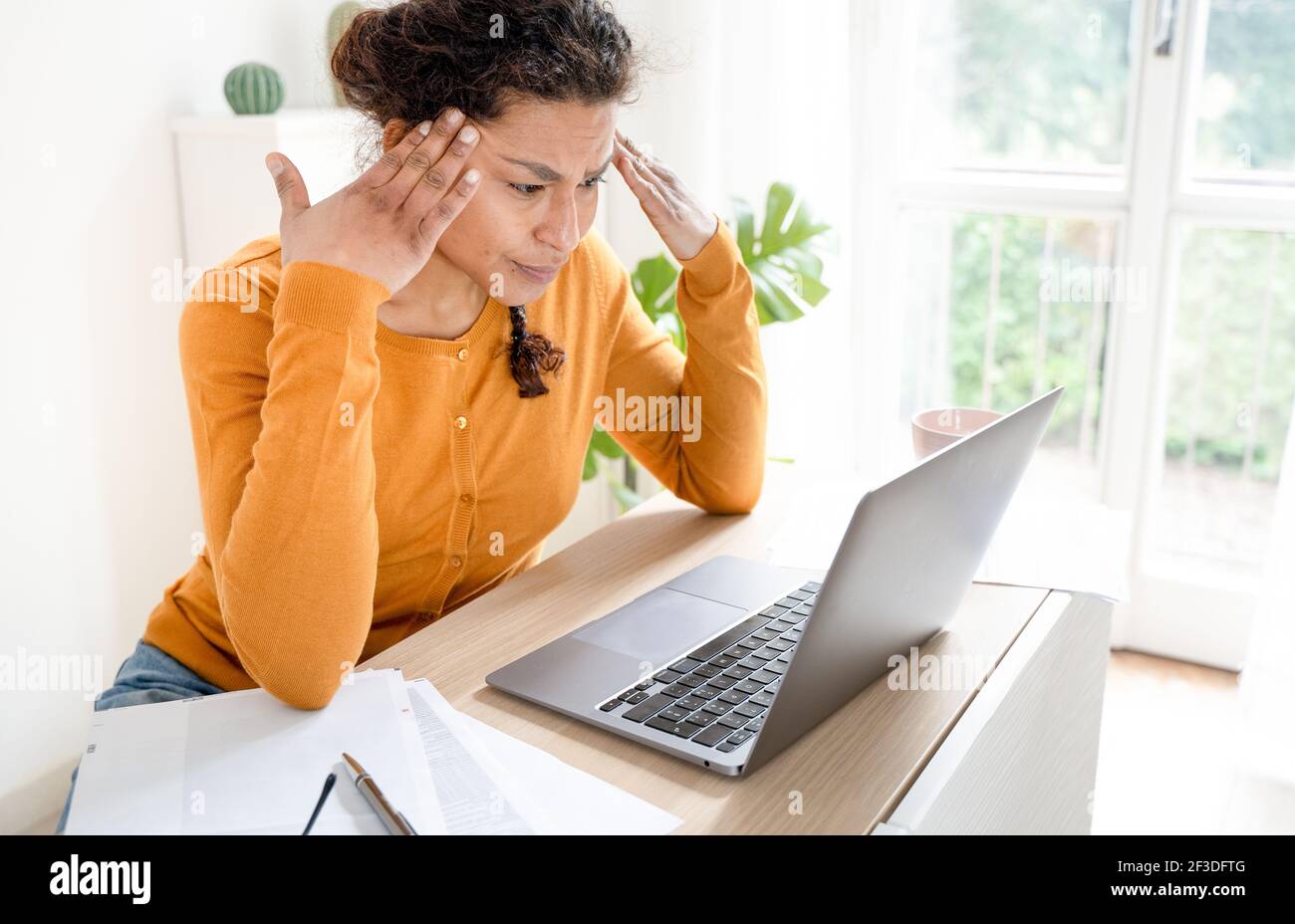 Woman feeling tired and overworked working from home Stock Photo