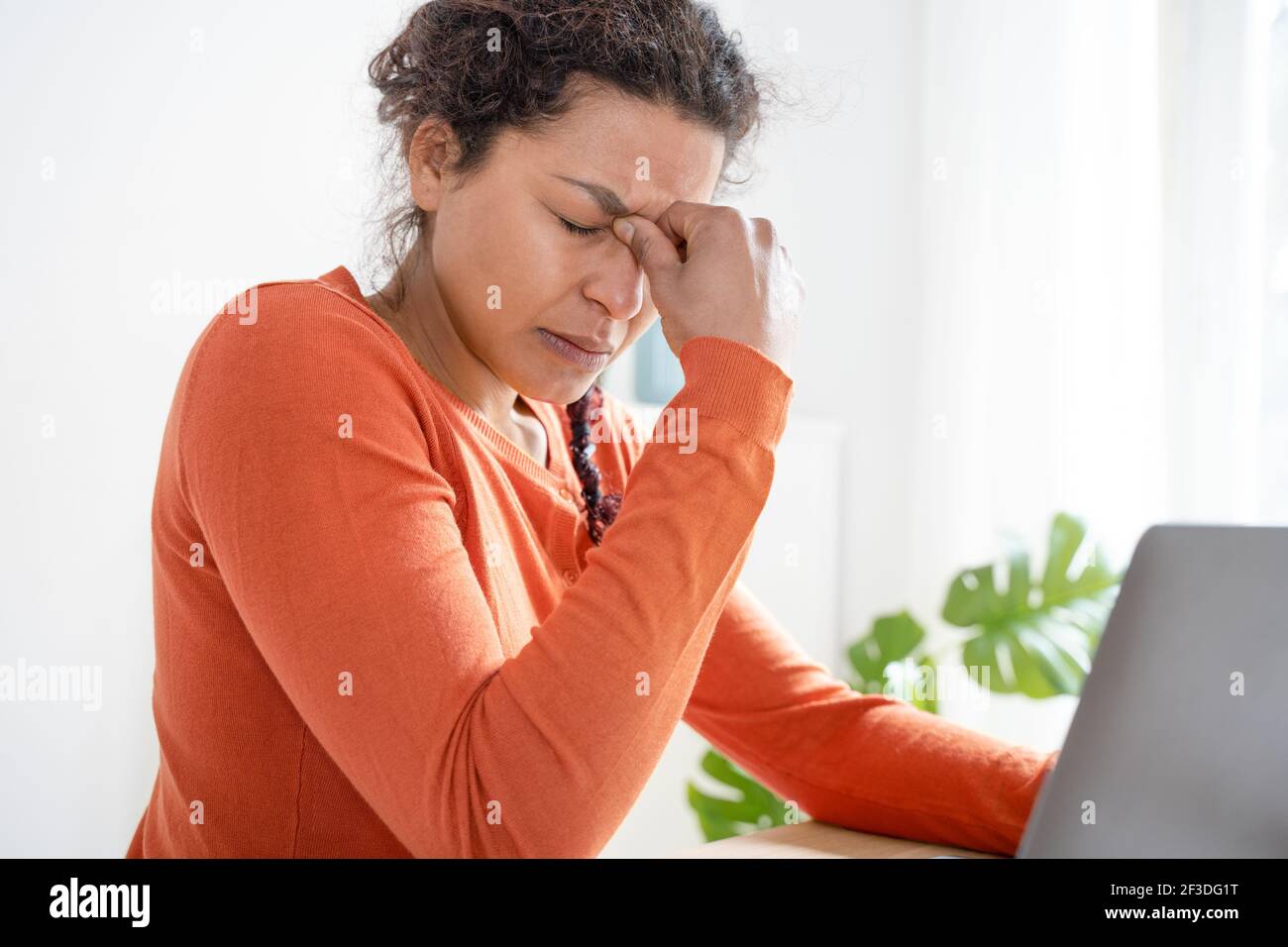 Woman feeling tired and overworked working from home Stock Photo