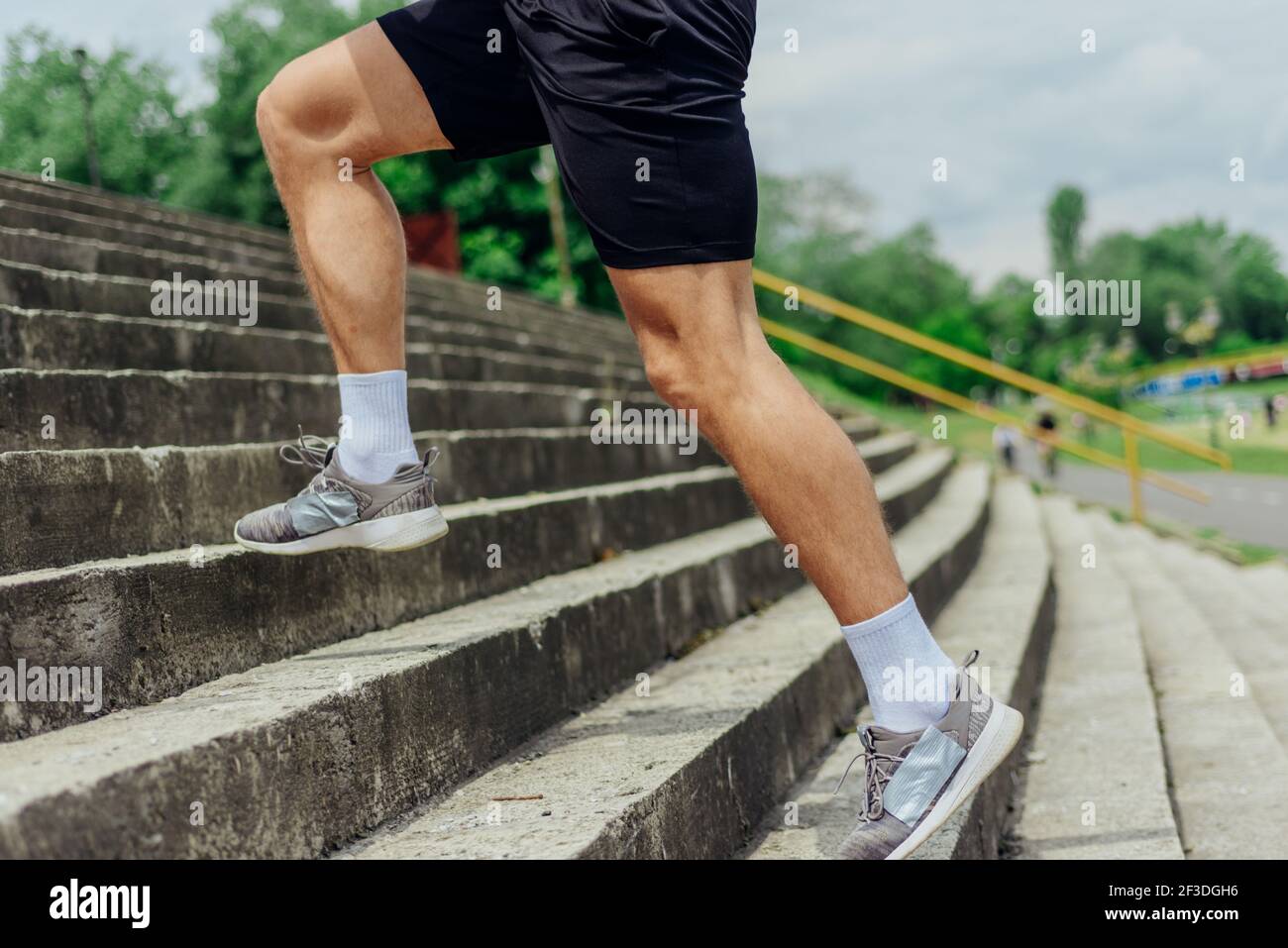 Fit male athlete performing stairs workout, running up climbing stairs
