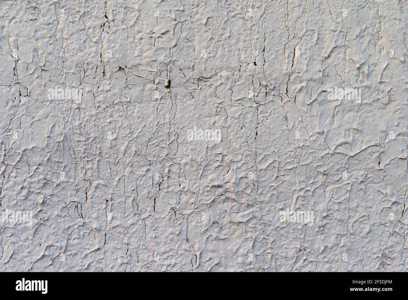 Wide view of a badly eroding and cracking exterior stucco white painted ...