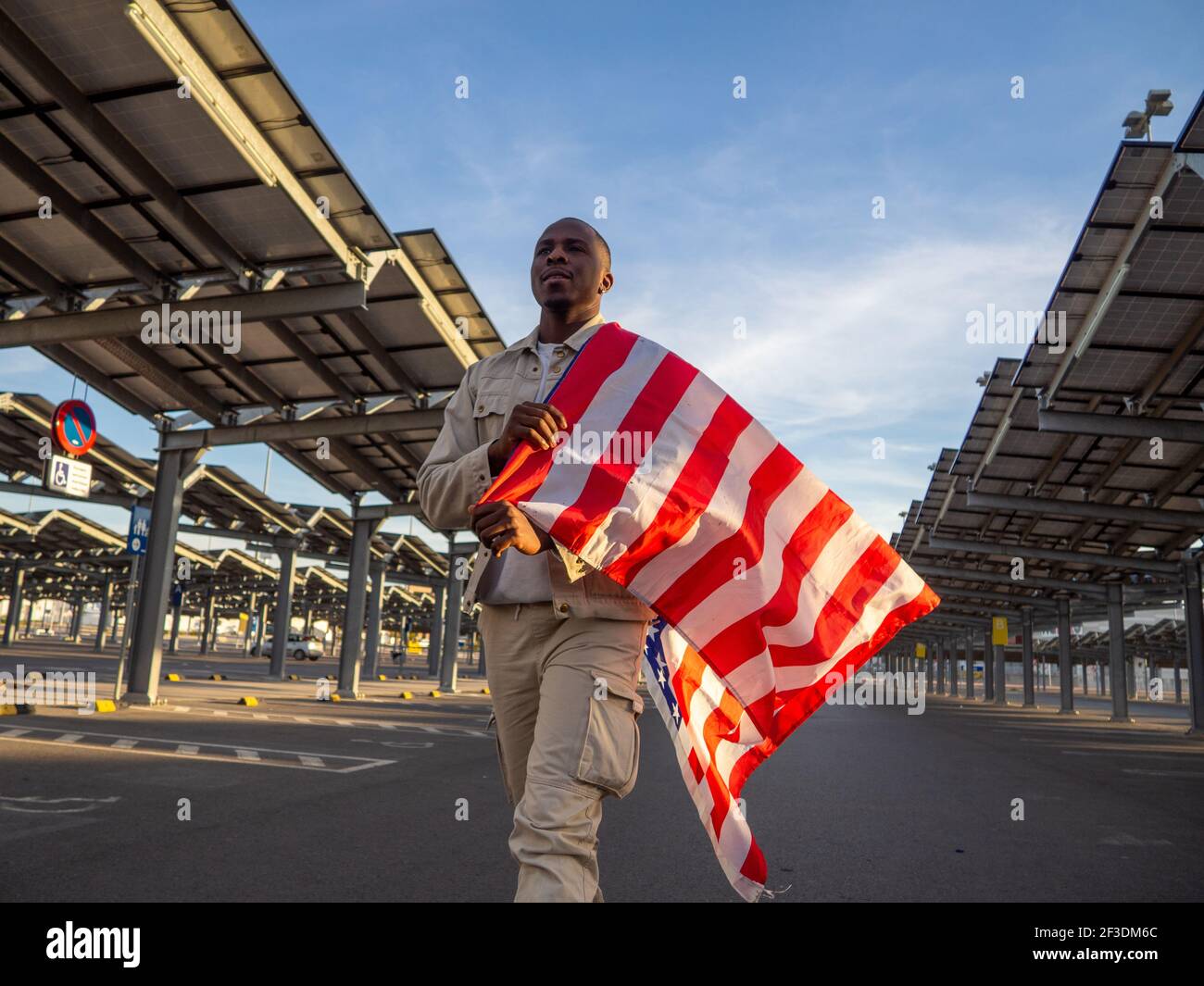 A handsome black Spanish male with an American flag in a parking lot ...