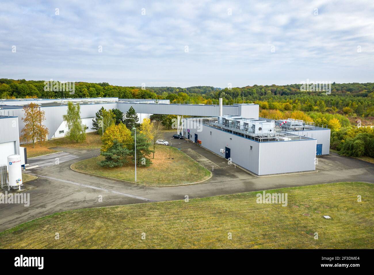 Elevated view of modern industrial buildings in logistic park surrounded by trees. Industry, transport and logistics. Stock Photo