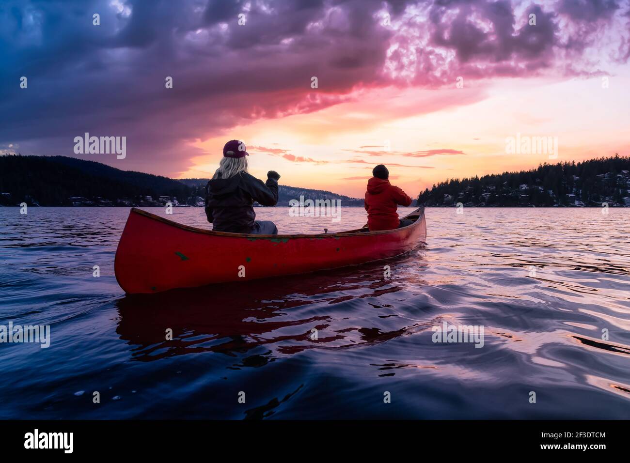 Couple friends on a wooden canoe are paddling in water Stock Photo - Alamy