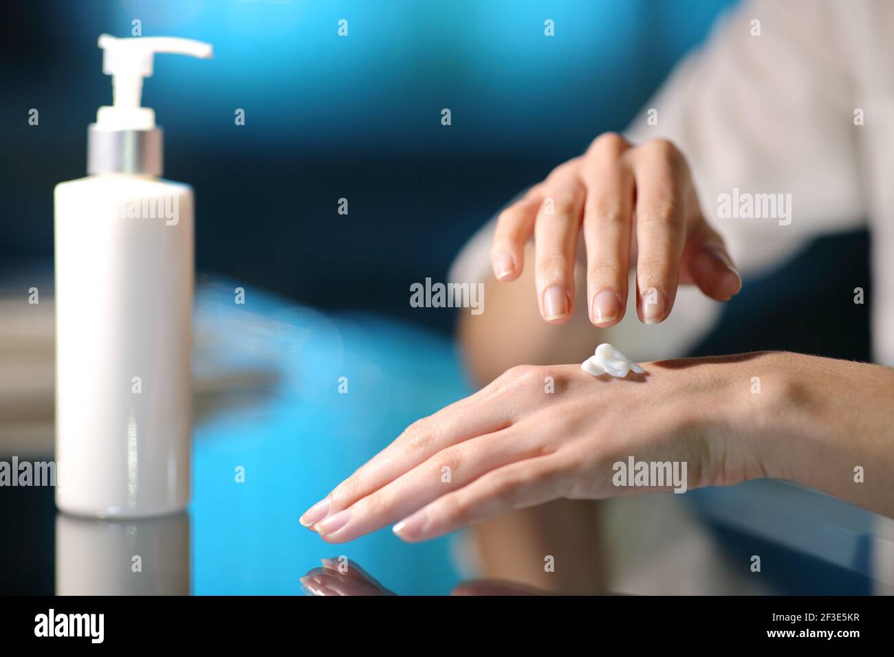 Close up of a woman hands rubbing moisturizer cream in the night at home Stock Photo