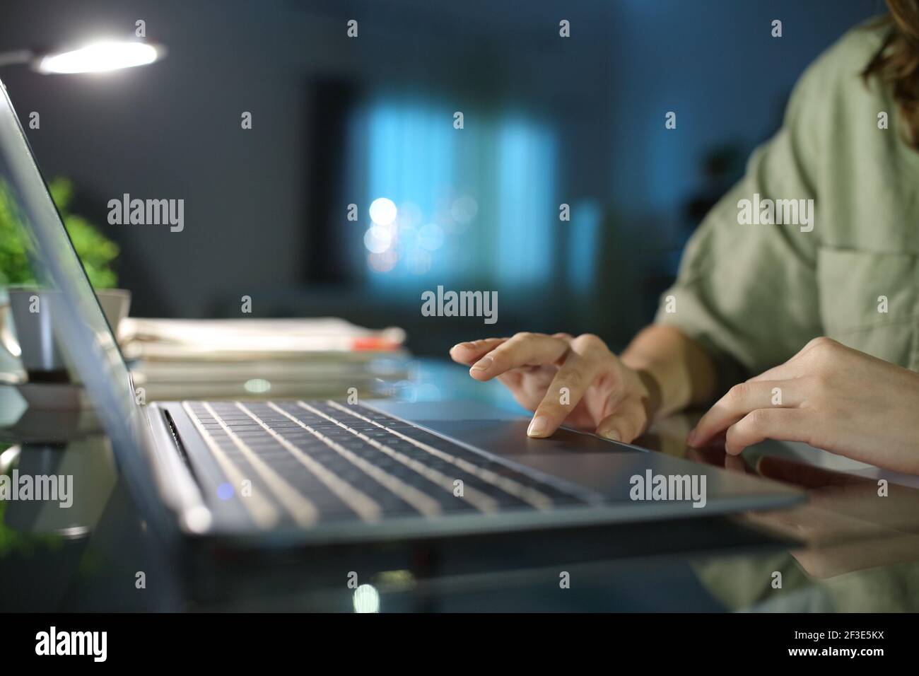 Close up of a woman hand browsing on laptop using touchpad in the night at home Stock Photo
