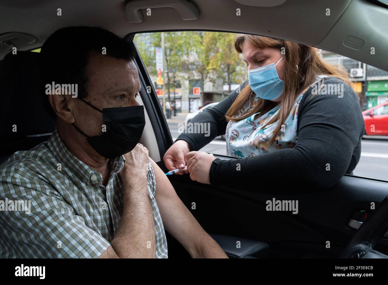 March 16, 2021, Santiago, Metropolitana, Chile: A man is vaccinated with his second dose of the Sinovac COVID-19 vaccine at a drive-thru vaccination site in Santiago, Chile. So far, almost 5 million people have been vaccinated in the country, and 41% of them with the second dose. (Credit Image: © Matias Basualdo/ZUMA Wire) Stock Photo