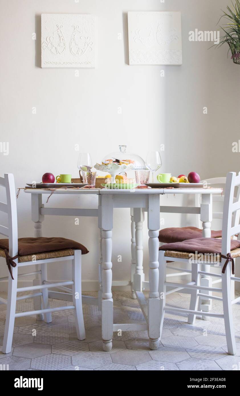 A rental bed and breakfast apartment in Sassari Sardinia Italy. Dinning table and chairs set-up with breakfast. Stock Photo