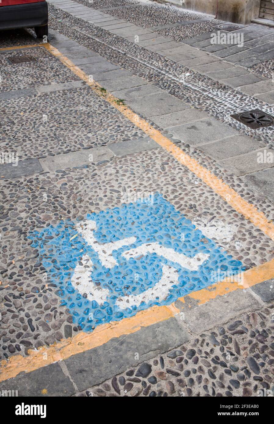 Allocated Disabled parking space on a cobbled street within Sassari which is a city in Sardinia Italy. Stock Photo