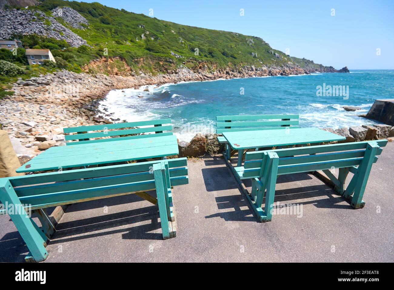Tables and bench chairs overlooking Lamorna Cove in Cornwall Stock Photo