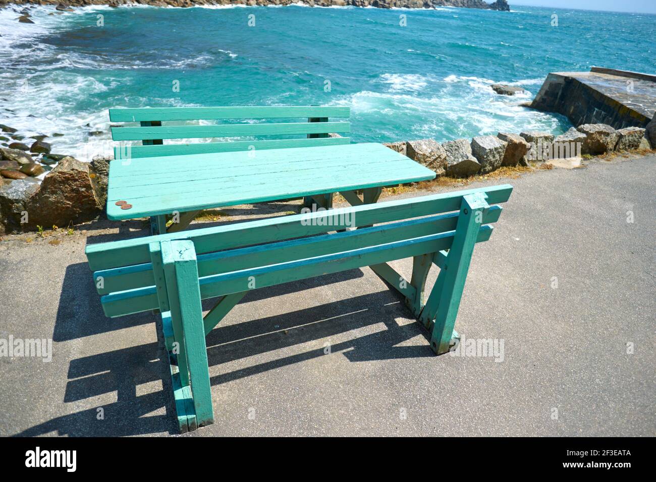 Table and bench chairs overlooking Lamorna Cove in Cornwall Stock Photo