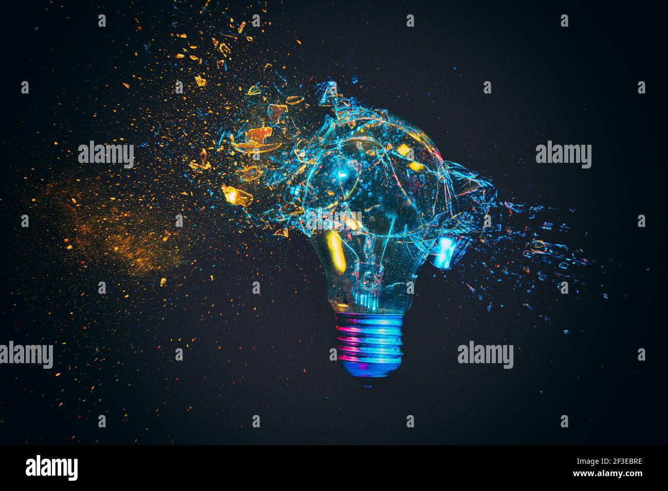 breaking of a traditional light bulb photographed in the instant of impact. Stock Photo