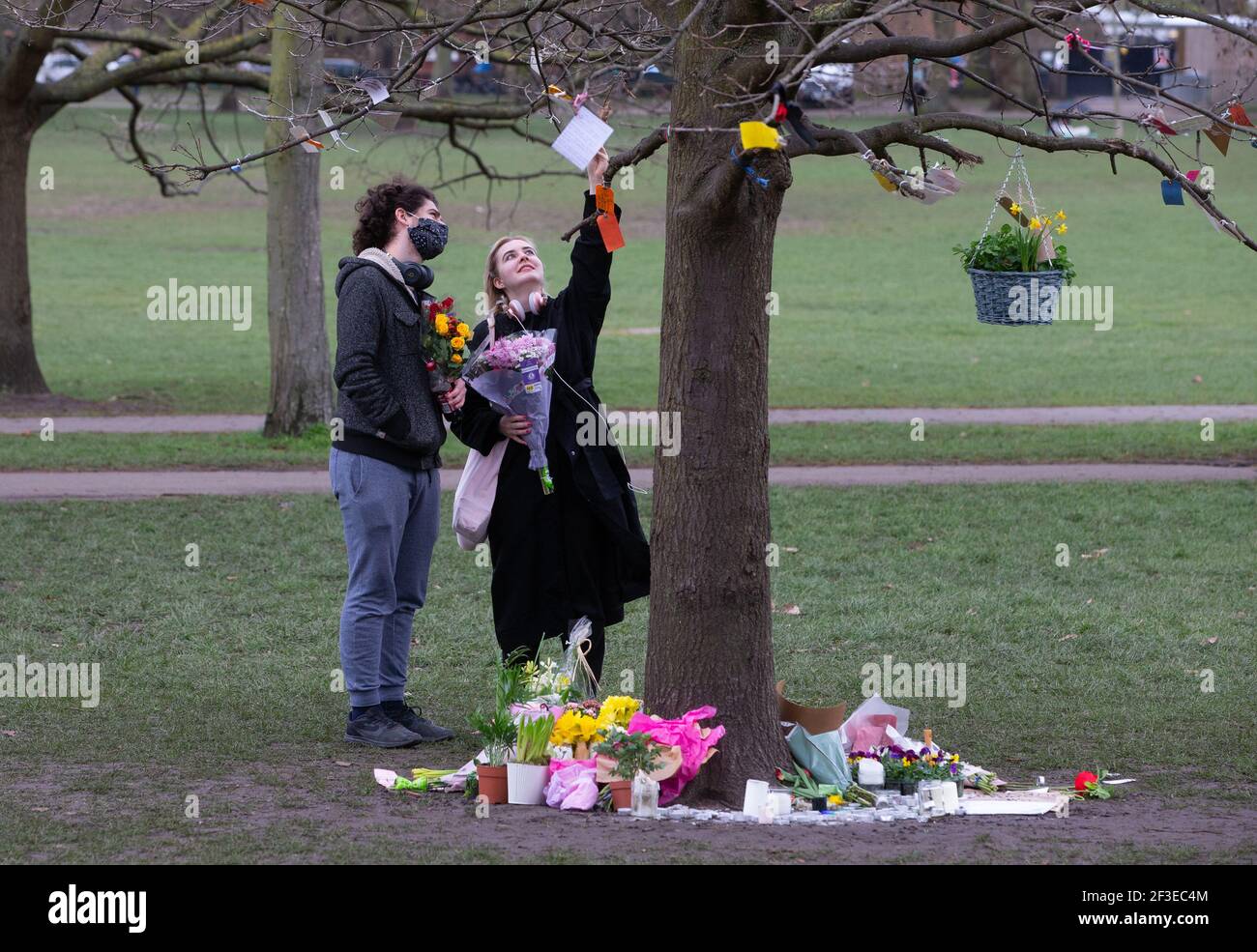 London, UK. 16th Mar, 2021. People read tributes to Sarah Everard tied to the branches of a tree on Clapham Common. People continue to leave tributes and flowers for Sarah Everard at the bandstand on Clapham Common which has become a shrine. Sarah was last seen on March 3rd. Her body was found in a builders' bag in Woodland at Ashord. PC Wayne Couzens appeared at the Old Bailey via videolink from Belmarsh prison today. He will go on trial in October. Credit: Mark Thomas/Alamy Live News Stock Photo